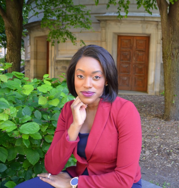 Krystal Meek, Registered Psychotherapist, seated outdoors in a red blazer